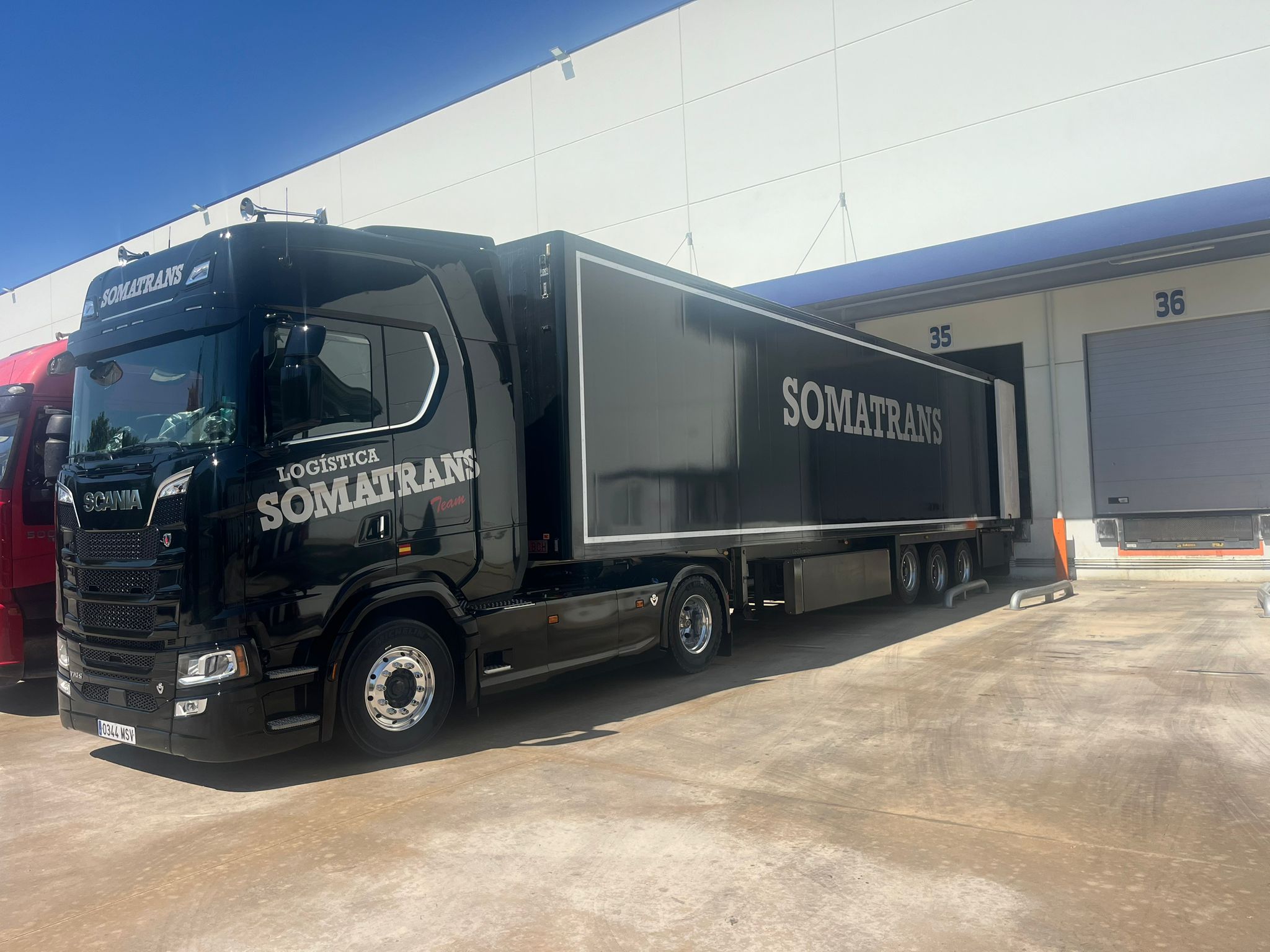 Scania negro de Somatrans delante de los muelles de carga